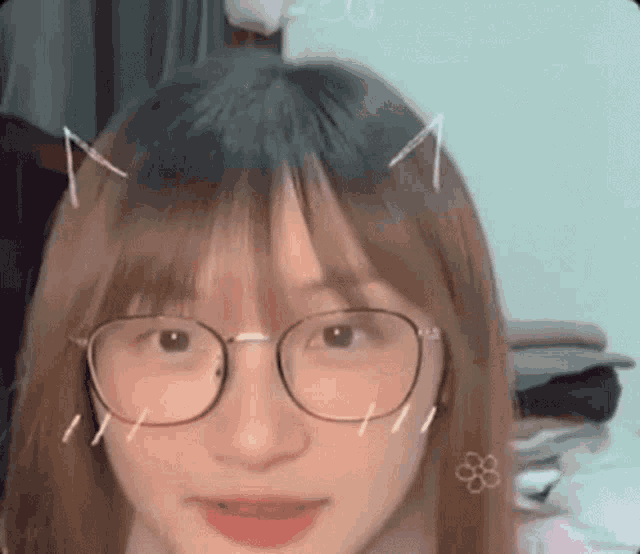 a close up of a woman wearing glasses and cat ears .