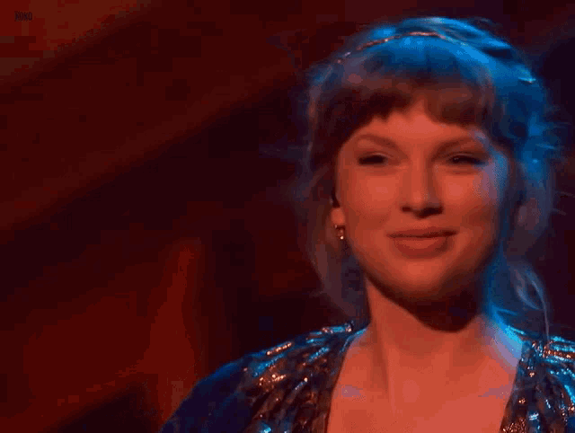 a close up of a woman 's face on a stage in a dark room .