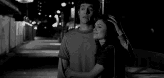a man is kissing a woman on the forehead in a black and white photo .