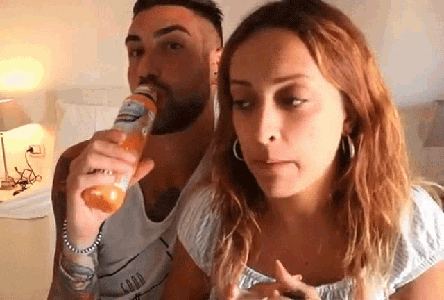 a man is drinking from a bottle that says ' good ' on it