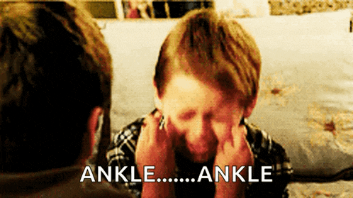 a boy is covering his face with his hands and the words ankle are written above him