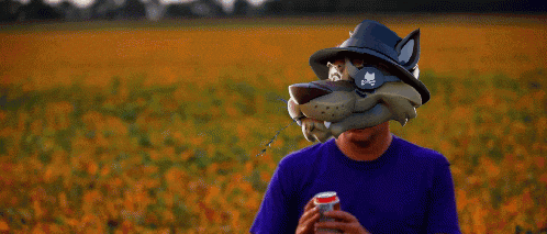 a man wearing a wolf mask is drinking from a can of soda