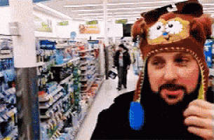 a man with a beard is wearing a garfield hat and holding a toothbrush