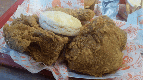 fried chicken and a biscuit on a tray that says ' popeye ' on it