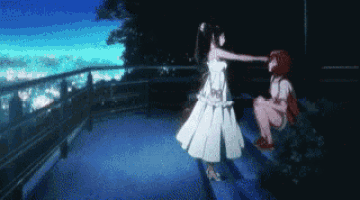 a girl in a white dress is standing next to a boy in a red shirt on a balcony .