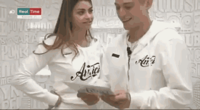 a man and a woman are standing next to each other wearing shirts with the word amici on them