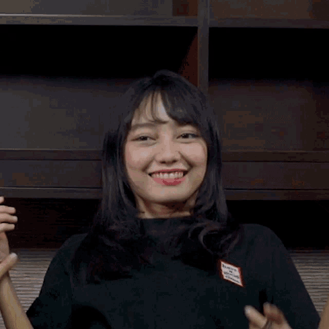 a woman wearing a black shirt with a red sticker on it that says ' i love you '