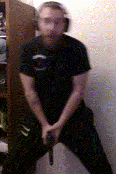 a man with a beard is holding a gun in a blurry photo