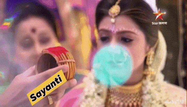 a bride blowing a bubble with the name sayanti written on it