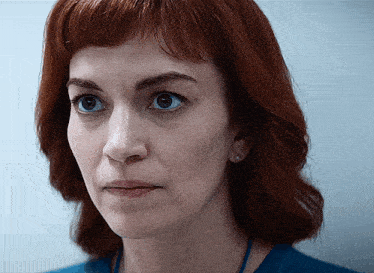 a close up of a woman 's face with a blue shirt around her neck