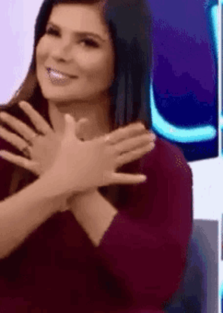 a woman is sitting in a chair with her hands folded in front of her face .