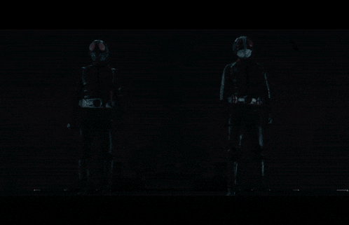 two monsters with red eyes are standing next to each other in the dark