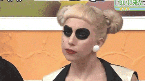 a woman with blonde hair and black eye shadow looks at the camera .