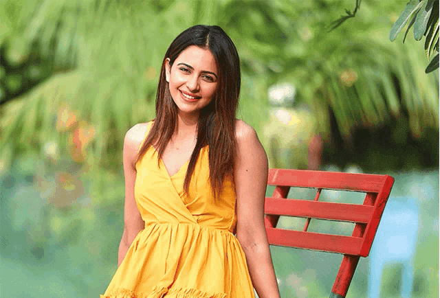 a woman in a yellow dress sitting on a red chair