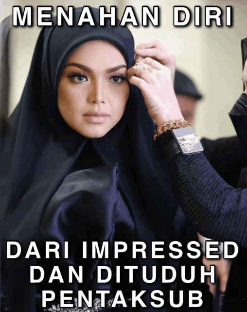 a woman in a hijab is getting her makeup done by a man