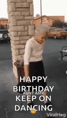 an older woman is dancing in front of a brick wall .