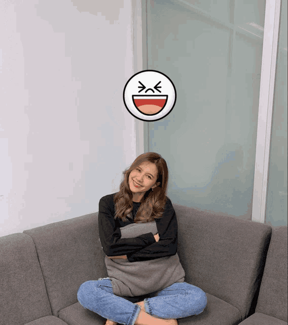 a woman sitting on a couch with her arms crossed and a smiley face above her head