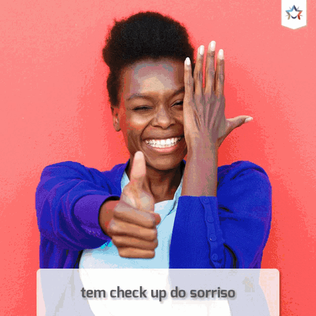 a woman in a blue jacket giving a thumbs up sign