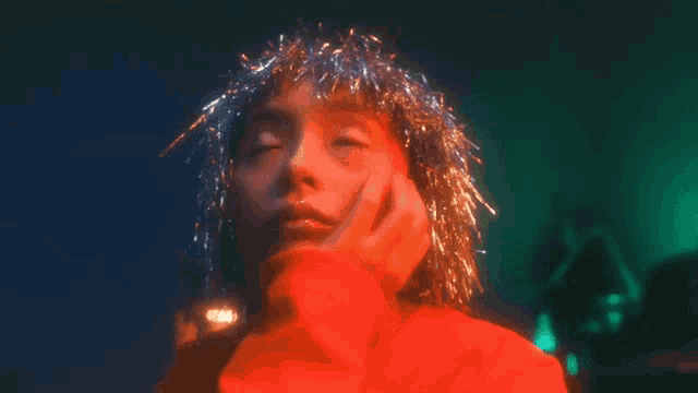 a woman wearing a red sweater and tinsel on her head