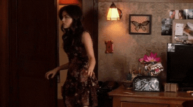 a woman in a dress is standing in a room
