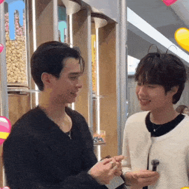 a couple of young men are standing next to each other in a store .