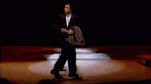 a man in a suit and tie is walking on a stage .