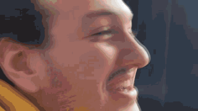 a close up of a man 's face with a beard making a funny face