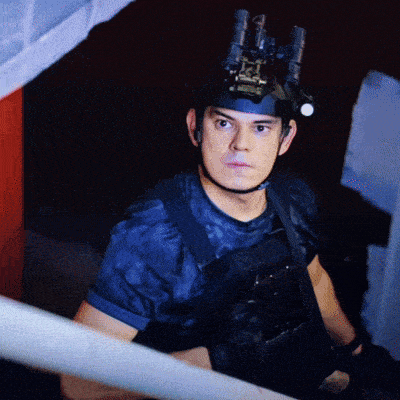 a man wearing a helmet with binoculars on it looks at the camera