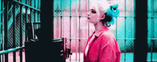 harley quinn is standing in a jail cell with a machine behind her .