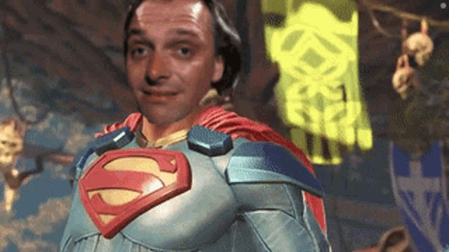 a man in a superman costume is smiling in front of a yellow flag