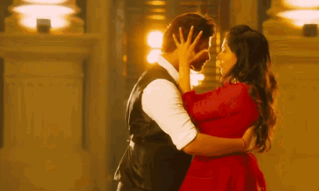 a man and a woman are dancing and the woman is in a red dress
