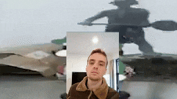 a man is standing in front of a mirror with a shadow of a man on the wall behind him