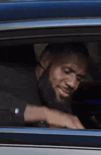a man is looking out of a car window