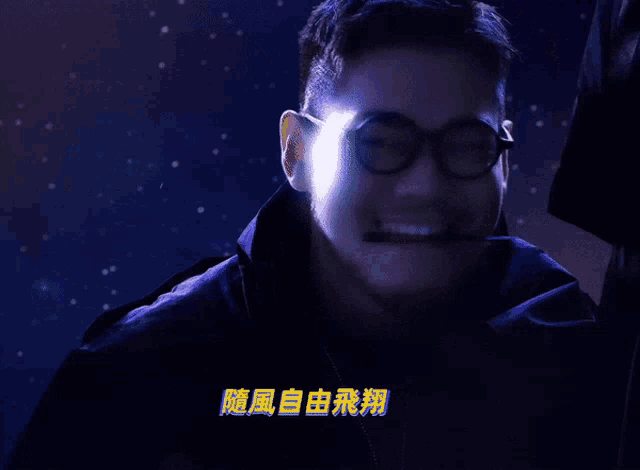 a man wearing glasses and a headset with chinese characters on the bottom right