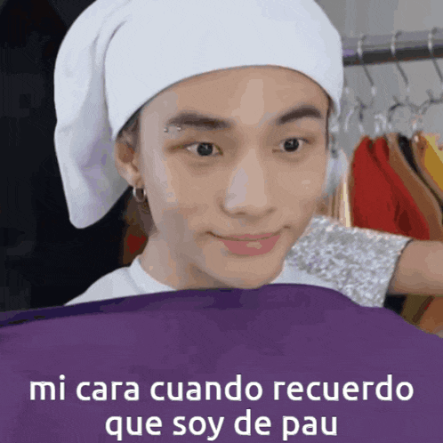 a man wearing a white hat is holding a purple cloth with the words mi cara cuando recuerdo que soy de pau written on it