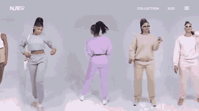a group of women are standing next to each other wearing different colored clothes .