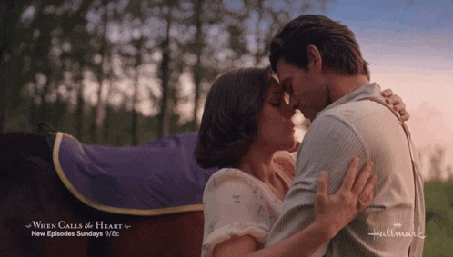 a man and woman kissing in front of a horse with the words when calls the heart