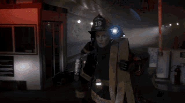 a fireman with the number 19 on his helmet is holding a hose