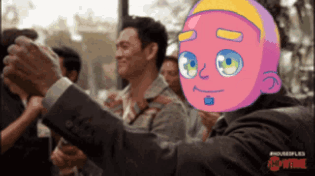 a man in a suit is taking a picture of himself with a cartoon face on his head