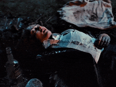 a person laying on the ground with a bottle of jack daniels