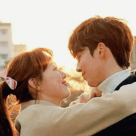 a man and a woman are looking at each other and hugging .