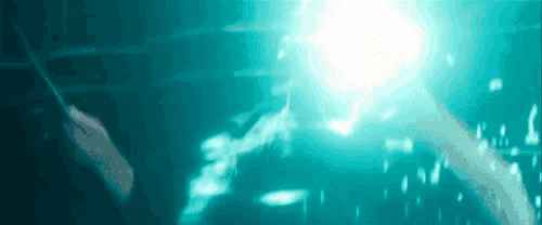 a blurry picture of a person holding a wand in a dark room