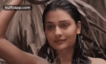 a naked woman is taking a shower with a bowl of water in her hand .