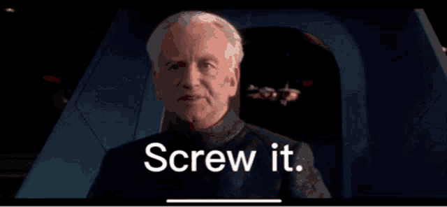 a man is sitting in a chair with the words screw it written on the screen behind him .