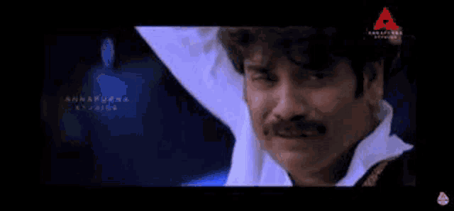 a man with a mustache is crying with his eyes closed in a movie .