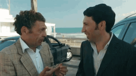 two men are standing next to each other and talking