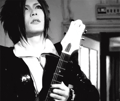 a black and white photo of a girl holding a guitar