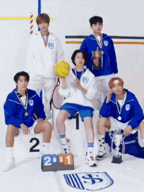 a group of athletes are posing for a picture with a trophy and the number 2
