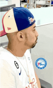 a man wearing a hat and a shirt with the number 76 on it