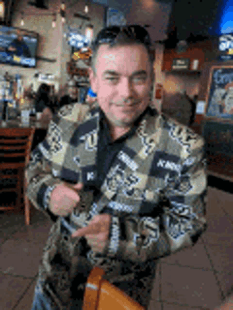 a man in a camouflage jacket is standing in a restaurant .